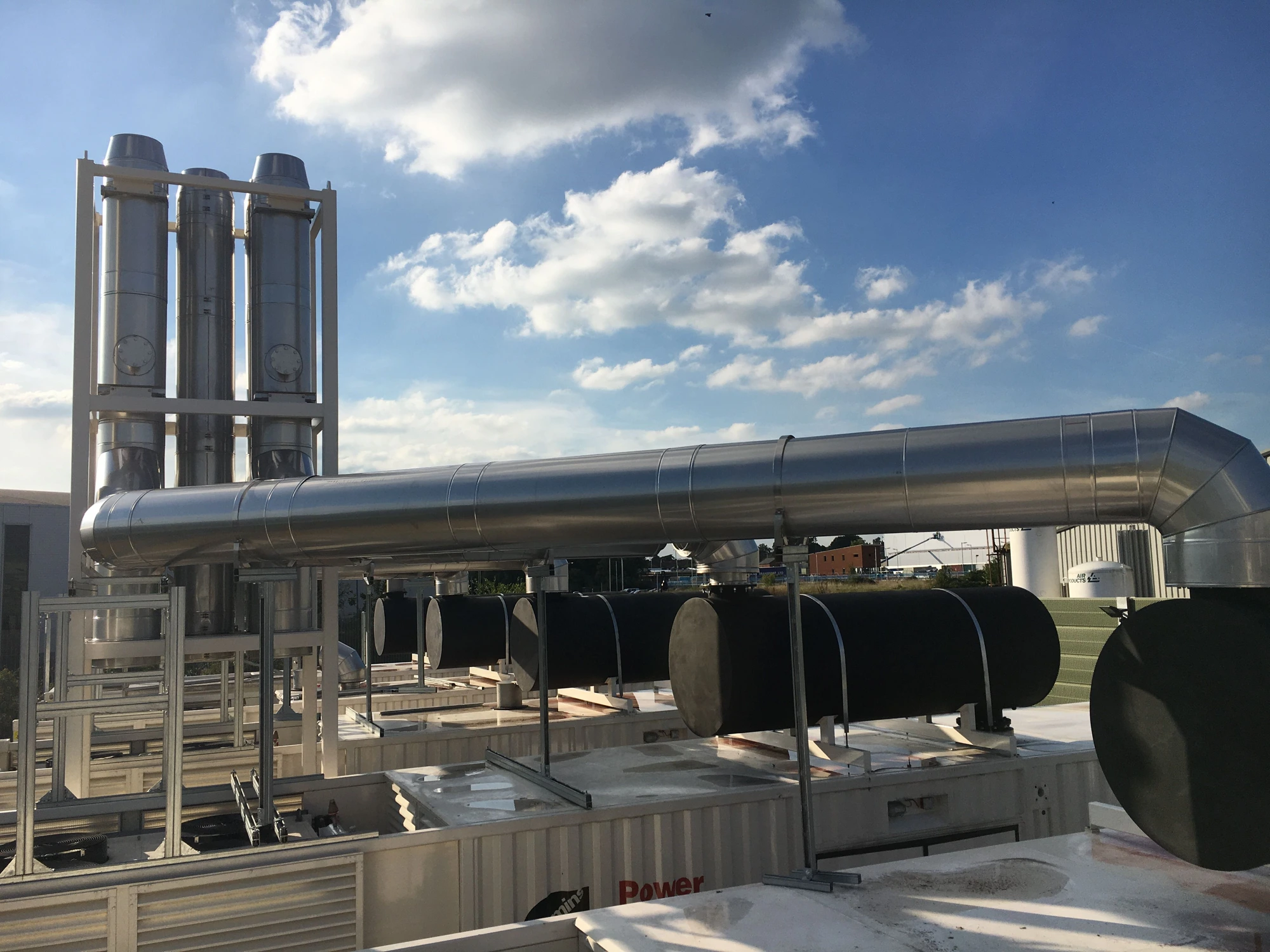 Industrial rooftop HVAC system with ductwork and equipment against blue sky